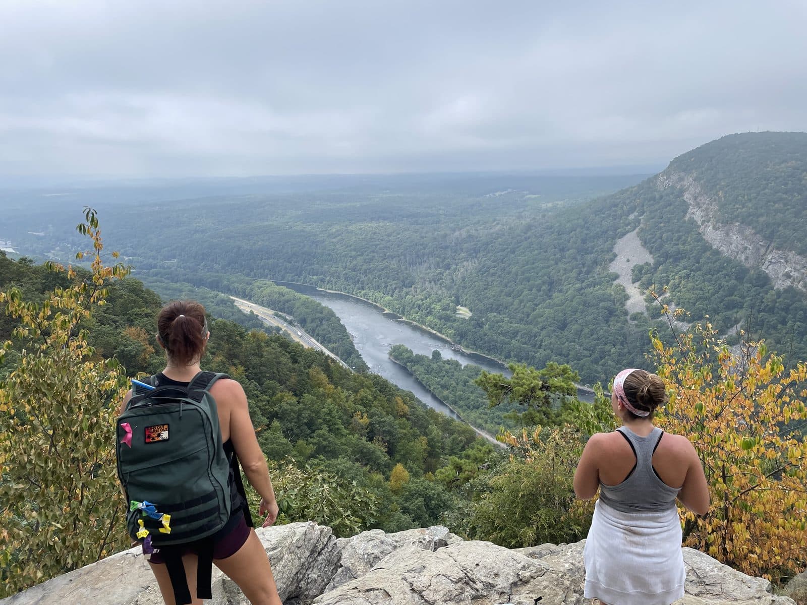Two ruckers seen from behind, looking out over the Delaware Water Gap from Mt. Tammany